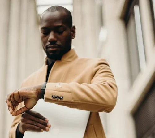 Man in Brown Overcoat Looking At The Time