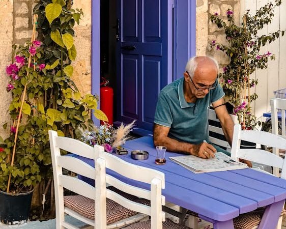 Man in Green Shirt Sitting on Wooden Chair